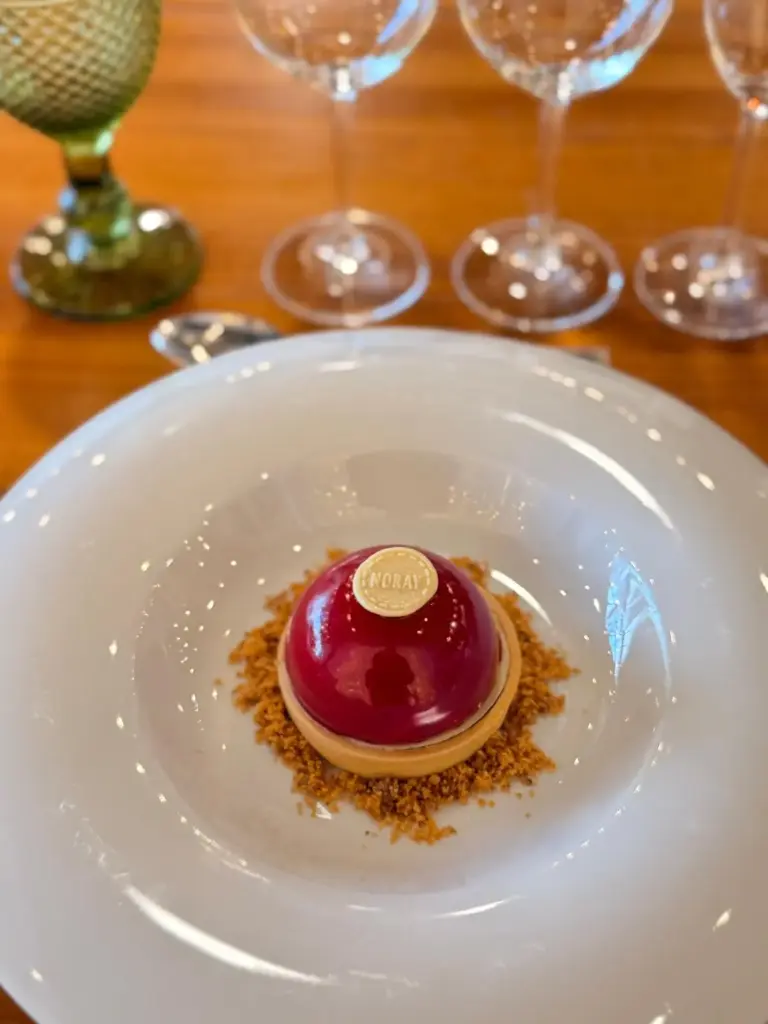 Semi esfera de chocolate blanco relleno de compota de ciruela y crujiente de almendra New